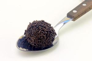 brigadeiro, brigadier, dolce al cioccolato tipico della cucina brasiliana ricoperto di particelle, su fondo in legno. foto