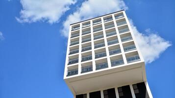 moderno appartamento edifici su un' soleggiato giorno con un' blu cielo. facciata di un' moderno appartamento costruzione. bicchiere superficie con luce del sole. foto