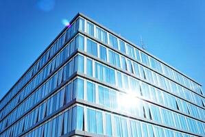 bicchiere edificio con trasparente facciata di il edificio e blu cielo. strutturale bicchiere parete riflettendo blu cielo. astratto moderno architettura frammento. contemporaneo architettonico sfondo. foto