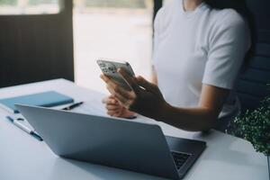 eccitato contento asiatico donna guardare a il Telefono schermo, festeggiare un in linea vincita, felicissimo giovane asiatico femmina urlando con la gioia, isolato al di sopra di un' bianca sfocatura sfondo foto