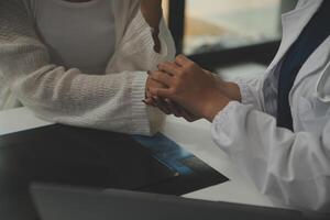 asiatico femmina medico dando speranza e incoraggiare per stressato donna paziente a Ospedale. sorridente medico donna toccante su paziente spalla per supporto prendere cura e porzione . supportato e incoraggiato foto