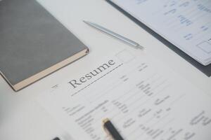 vicino su Visualizza di lavoro colloquio nel ufficio, messa a fuoco su curriculum vitae scrittura Consigli, datore di lavoro rivedere bene CV di preparato qualificato richiedente, reclutatore considerando applicazione, hr manager fabbricazione assumere decisione foto