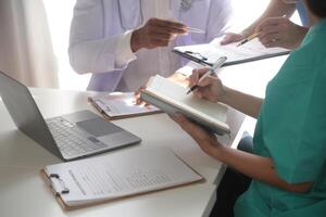 medico squadra incontro in giro tavolo nel moderno ospedale foto