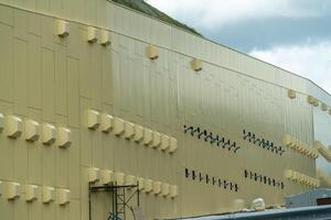 un' grande edificio con molti finestre e prese d'aria. il edificio è giallo e ha un' lotto di finestre. foto