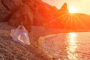 misterioso donna silhouette lungo capelli passeggiate su il spiaggia oceano acqua, mare ninfa vento ascolta per il onda. lanci su un' lungo bianca vestire, un' divine tramonto. artistico foto a partire dal il indietro senza un' viso