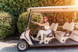 un' di mezza età donna è guida un' auto per trasporto turisti. elettrico macchina, turista autobus. auto per trasporto persone in giro il Hotel, foto