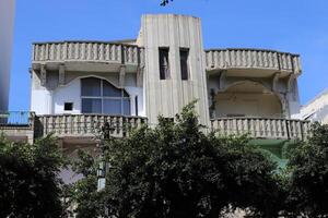 edifici e strutture nel tel aviv contro il sfondo di rami e le foglie di alto alberi. foto