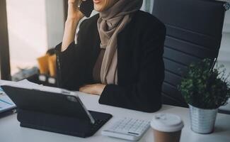 tiro di un attraente maturo donna d'affari Lavorando su il computer portatile nel sua postazione di lavoro. foto