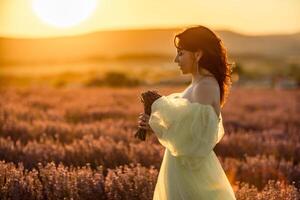 donna lavanda campo. contento donna nel giallo vestito nel lavanda campo estate tempo a tramonto. aromaterapia concetto, lavanda olio, foto sessione nel lavanda