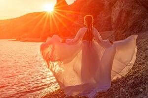 misterioso donna silhouette lungo capelli passeggiate su il spiaggia oceano acqua, mare ninfa vento ascolta per il onda. lanci su un' lungo bianca vestire, un' divine tramonto. artistico foto a partire dal il indietro senza un' viso