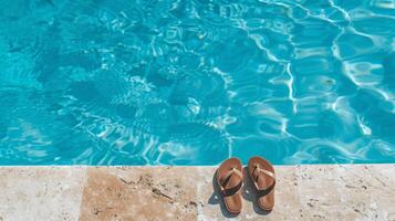 paio di infradito sinistra a il bordo di piscina, segnalazione spensierato estate giorno foto