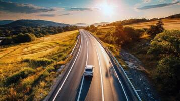 strada viaggio attraverso nazione strade, circondato di i campi di baciato dal sole colture nel il altezza di estate foto