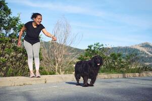 contento allegro donna a piedi sua cane su guinzaglio nel il natura foto