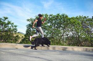 sportivo attivo donna in esecuzione con sua cane su guinzaglio nel montagne natura. le persone. giocando animali domestici. amore per animali e natura concetto foto