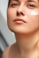 bellezza, abbronzatura spf e cura della pelle cosmetici modello viso ritratto, donna con idratante crema, protezione solare Prodotto o sole abbronzatura lozione su sua guancia, lusso facciale e pelle cura foto