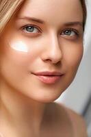 bellezza, abbronzatura spf e cura della pelle cosmetici modello viso ritratto, donna con idratante crema, protezione solare Prodotto o sole abbronzatura lozione su sua guancia, lusso facciale e pelle cura foto