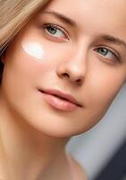 bellezza, abbronzatura spf e cura della pelle cosmetici modello viso ritratto, donna con idratante crema, protezione solare Prodotto o sole abbronzatura lozione su sua guancia, lusso facciale e pelle cura foto