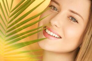 estate bellezza, trucco e cura della pelle, viso ritratto di bellissimo donna con tropicale palma albero foglia, naturale trucco per cosmetici e moda Guarda foto