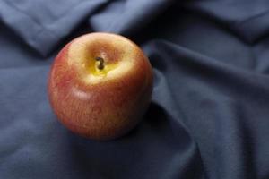 mela rossa su panno blu foto