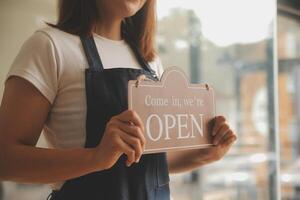 avvio di successo della piccola impresa titolare sme bellezza ragazza stand con tablet smartphone nel ristorante caffetteria. ritratto di donna asiatica abbronzata barista barista proprietario. concetto di business venditore imprenditore PMI foto