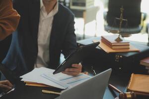 concetto di giustizia e diritto. il consulente legale presenta al cliente un contratto firmato con martelletto e diritto legale o una riunione del team legale presso uno studio legale in background foto