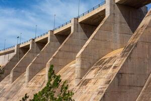 vicino lato parte inferiore Visualizza di un' asciutto calcestruzzo fiume diga a partire dal sotto foto