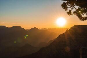 sereno tramonto al di sopra di aspro montagna creste, caldo d'oro leggero foto