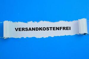 concetto di versandkostenfrei nel linguaggio Germania testo scritto nel strappato carta. foto