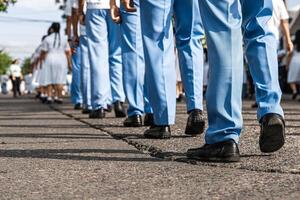 piedi di in uniforme uomini e donne in marcia nel un' parata su il strada. foto