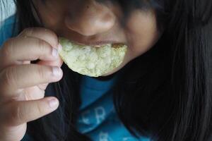 un' poco ragazza mangiare Patata patatine fritte foto