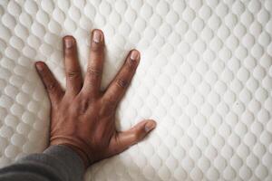 uomo mano su ortopedico cuscino su un' letto foto