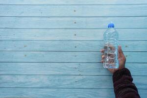 superiore Visualizza di mano Tenere un' plastica acqua bottiglia foto