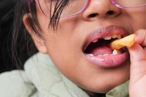 bambino mangiare francese patatine fritte vicino su foto