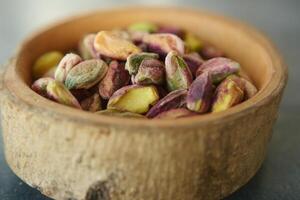di legno ciotola pieno con pistacchi, un' naturale e nutriente superfood foto