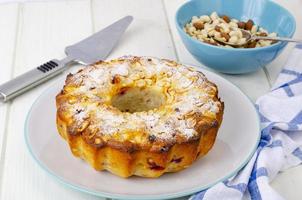 muffin fatti in casa d'oro con noci sul tavolo di legno bianco, tovagliolo. foto