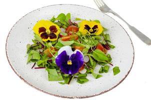 insalata di verdure con fiori commestibili su sfondo bianco. foto