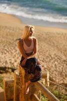 donna che si gode il tramonto su una bellissima spiaggia foto