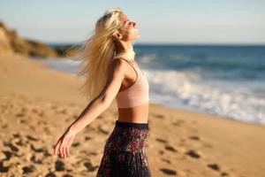 donna che si gode il tramonto su una bellissima spiaggia foto