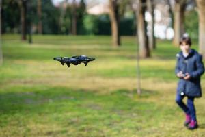 bambina di nove anni che manovra un drone giocattolo che vola con il telecomando