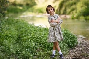 bambina nel flusso della natura che indossa un bel vestito foto