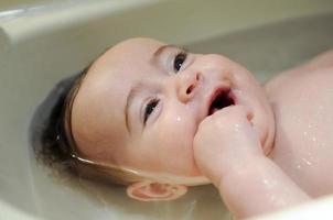 bambina di quattro mesi che fa il bagno foto