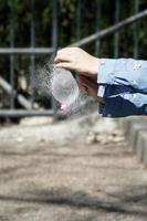 le mani di una ragazza che gonfiano un palloncino d'acqua con un ago foto