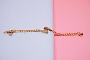 foto di un braccialetto da ragazza con un motivo a pendolo stravagante su uno sfondo rosa