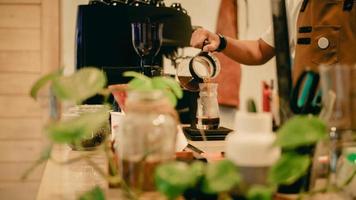 un barista maschio che prepara il caffè con il metodo aeropress foto