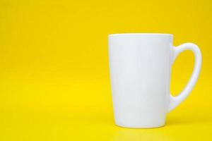 tazza in ceramica bianca su sfondo giallo foto