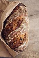pane fresco marrone con semi su fondo di legno vecchio foto