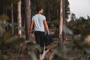 l'uomo in posa all'aperto nella foresta sta a piedi nudi su un tronco