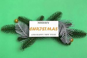 su rami di abete con decorazioni natalizie, un mockup di una cartolina con un'iscrizione su uno sfondo colorato. primo piano, copia spazio foto