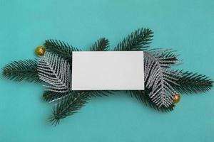su rami di abete con decorazioni natalizie, un mockup di una cartolina su uno sfondo colorato. da vicino, copia spazio. foto