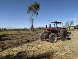 un trattore che ara un campo foto